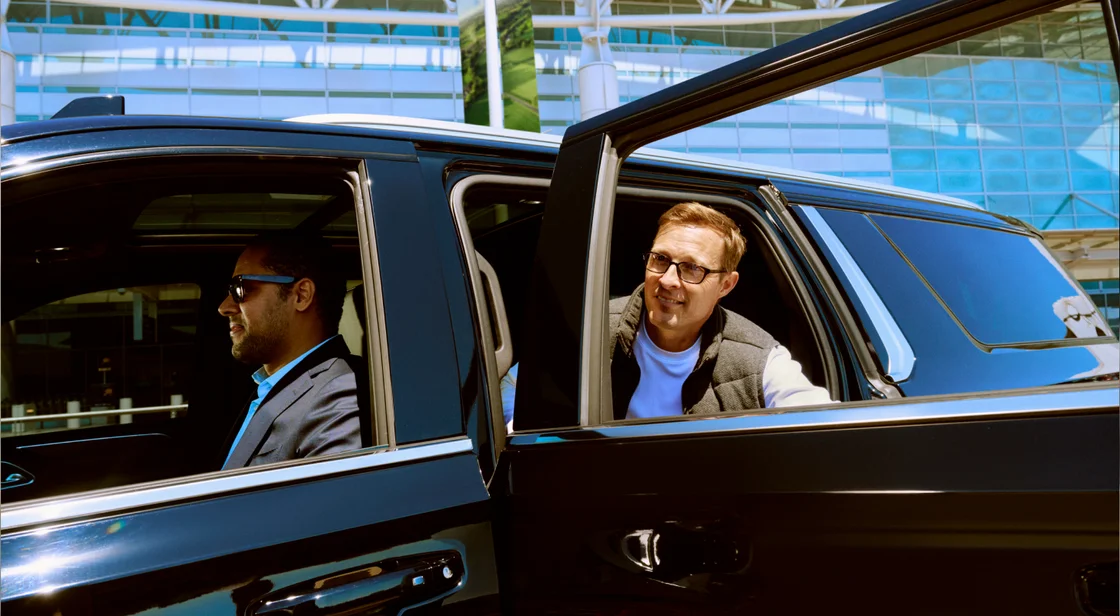 Lyft Business public photography: a passenger getting into a car outside an office building